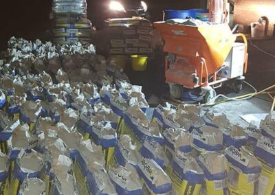 Render machine and bags of render lined up ready for a big overnight job at Swansea Car Showroom Liquid Screed - APW Homes